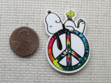 Second view of Snoopy on a peace sign needle minder. 
