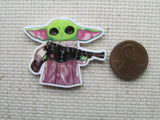 Second view of Grogu holding a weapon needle minder.