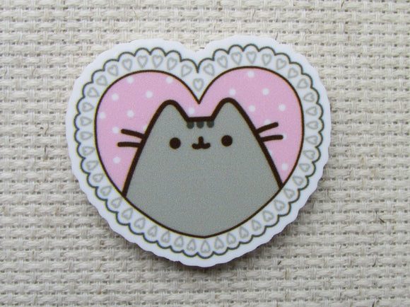 First view of grey cartoon cat in a pink heart needle minder.