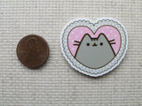 Second view of grey cartoon cat in a a pink heart needle minder.
