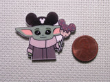 Second view of alien child as a tourist at Disney needle minder.